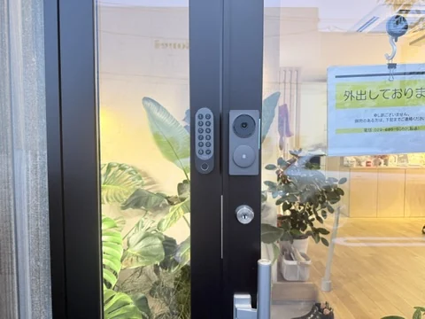 みどりのスタジオの入口。ガラスのドアの枠に、暗証番号のボタンが並ぶ機器と、カメラの付いた機器が取り付けられている